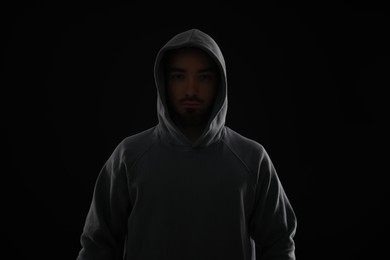 Photo of Criminal man in hood on dark background