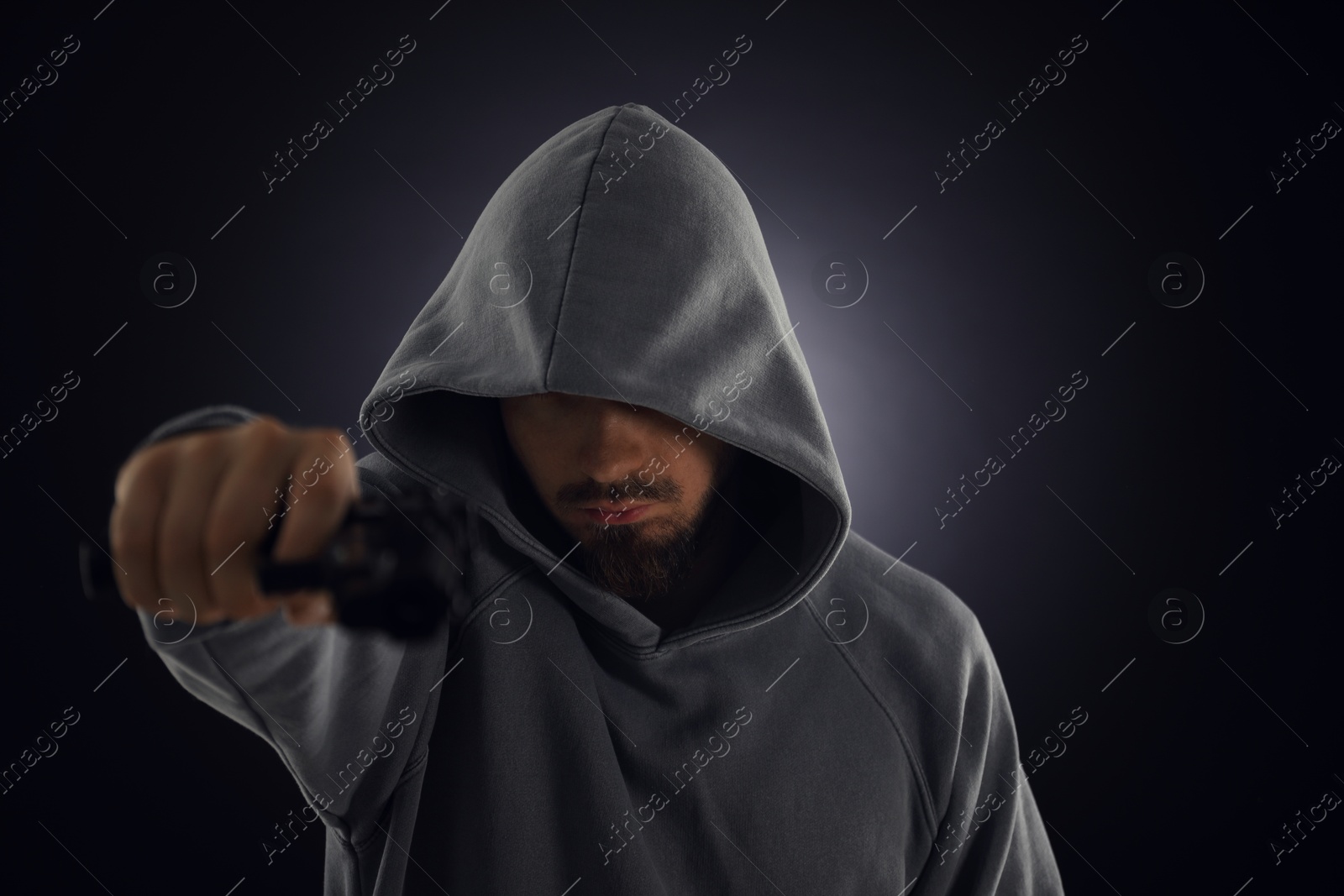 Criminal with gun on dark background, selective focus Photo of Criminal with gun on dark background, selective focus