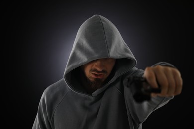 Photo of Criminal with gun on dark background, selective focus