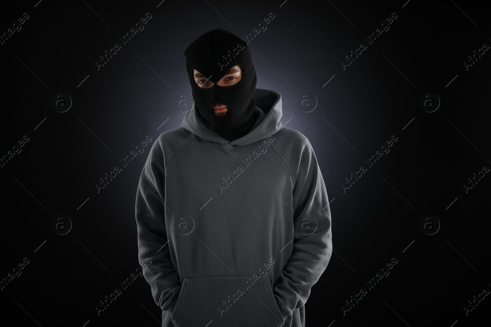 Criminal man in mask on dark background Photo of Criminal man in mask on dark background