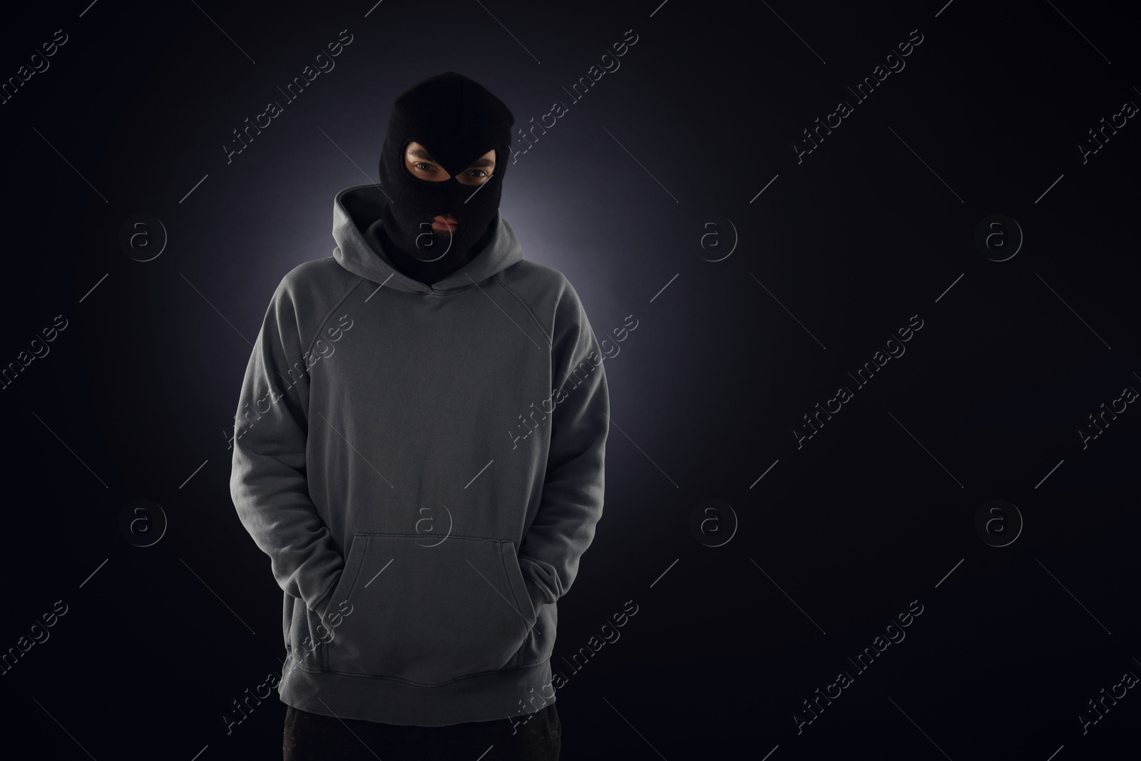 Criminal man in mask on dark background. Space for text Photo of Criminal man in mask on dark background. Space for text