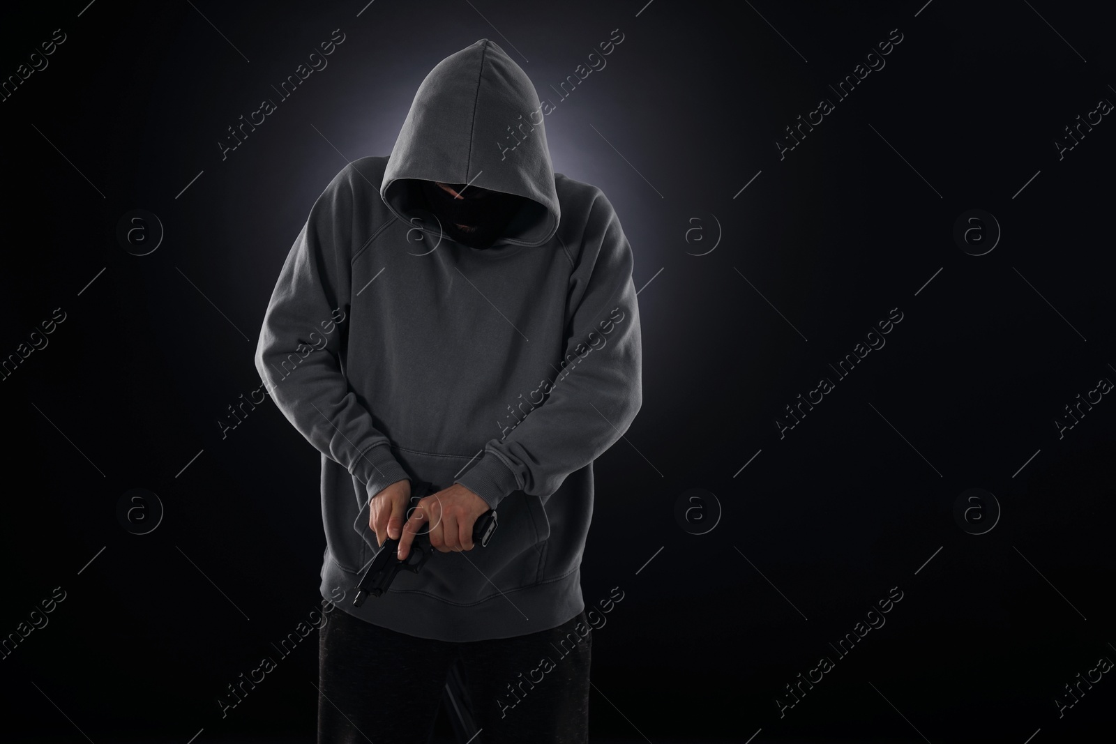 Criminal in mask with gun on dark background. Space for text Photo of Criminal in mask with gun on dark background. Space for text