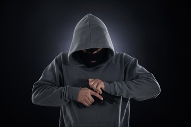 Photo of Criminal in mask with gun on dark background