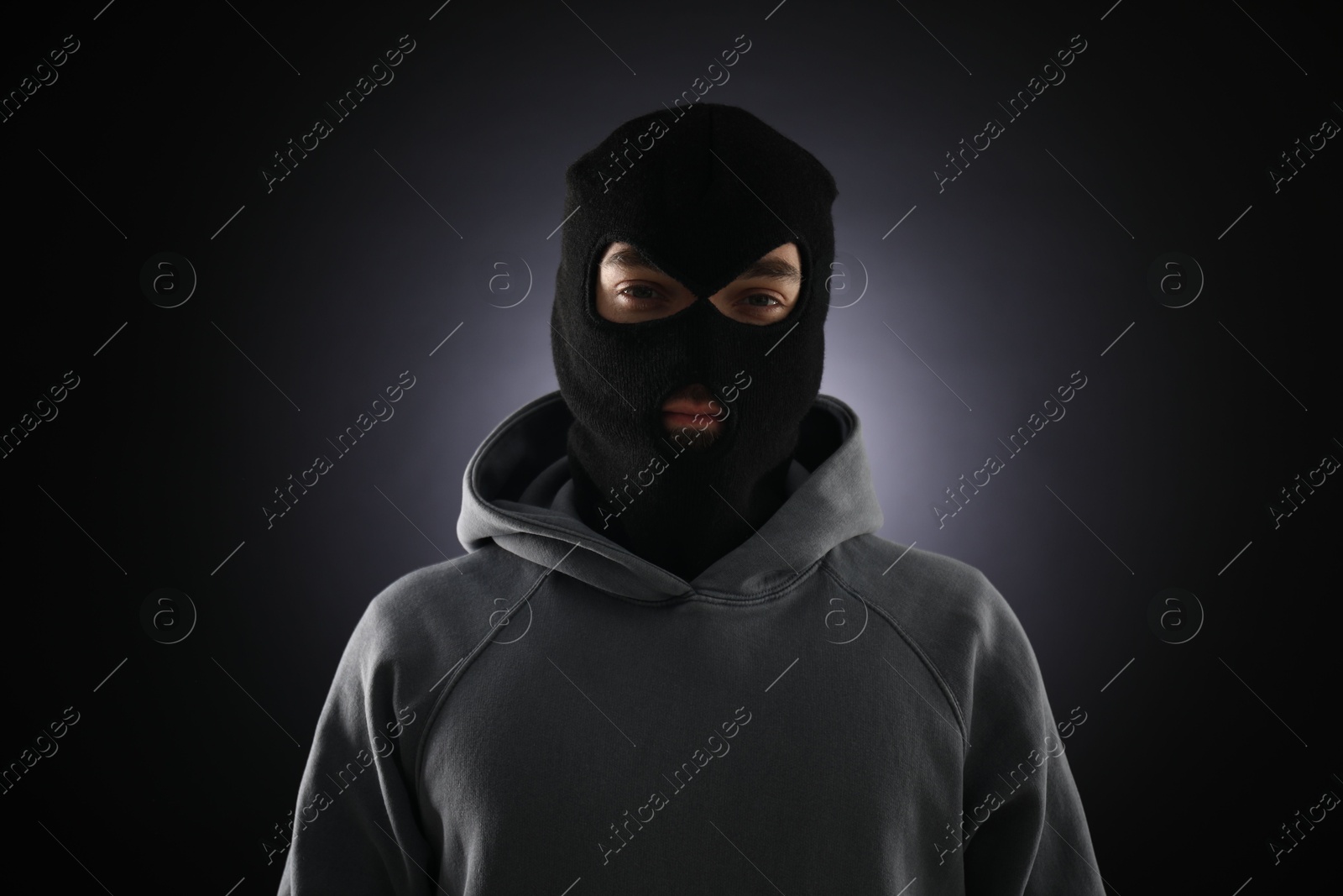 Criminal man in mask on dark background Photo of Criminal man in mask on dark background
