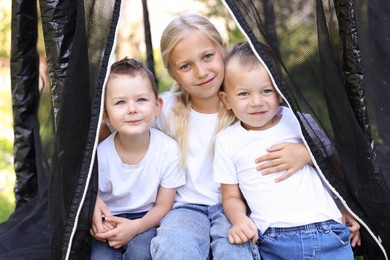 Photo of Happy children posing on black trampoline outdoors
