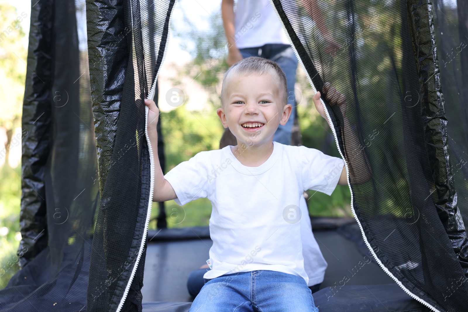 Happy little boy and his friends on black trampoline outdoors Photo of Happy little boy and his friends on black trampoline outdoors
