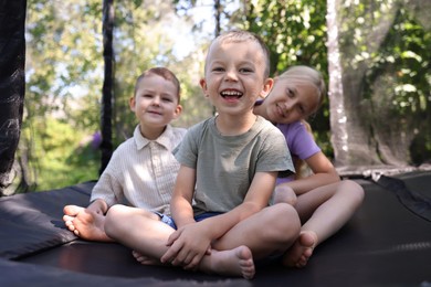 Photo of Happy friends having fun on black trampoline outdoors