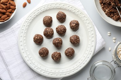Photo of Making tasty chocolate candies. Bonbons and ingredients on white table, flat lay