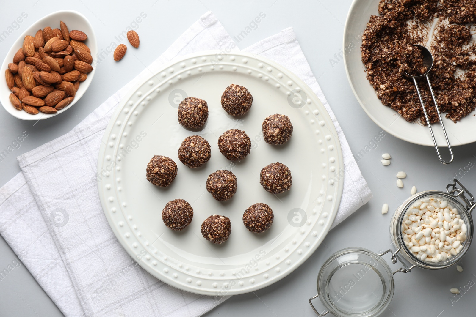 Photo of Making tasty chocolate candies. Bonbons and ingredients on white table, flat lay
