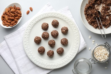 Photo of Making tasty chocolate candies. Bonbons and ingredients on white table, flat lay
