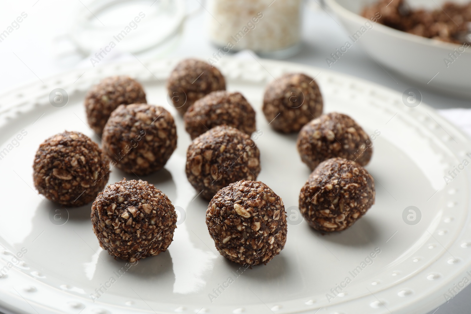 Tasty chocolate candies with nuts on white table, closeup Photo of Tasty chocolate candies with nuts on white table, closeup