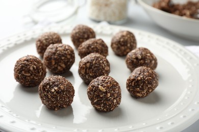 Photo of Tasty chocolate candies with nuts on white table, closeup
