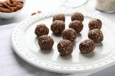 Photo of Tasty chocolate candies with nuts on white table, closeup