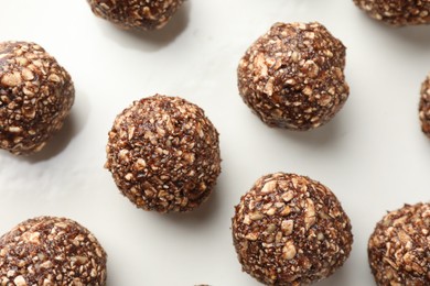 Photo of Tasty chocolate candies with nuts on white table, flat lay