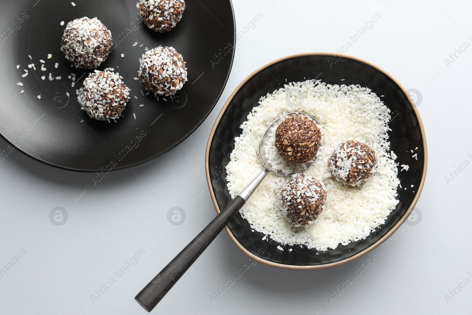 Making tasty chocolate candies with nuts and coconut flakes at white table, top view Photo of Making tasty chocolate candies with nuts and coconut flakes at white table, top view