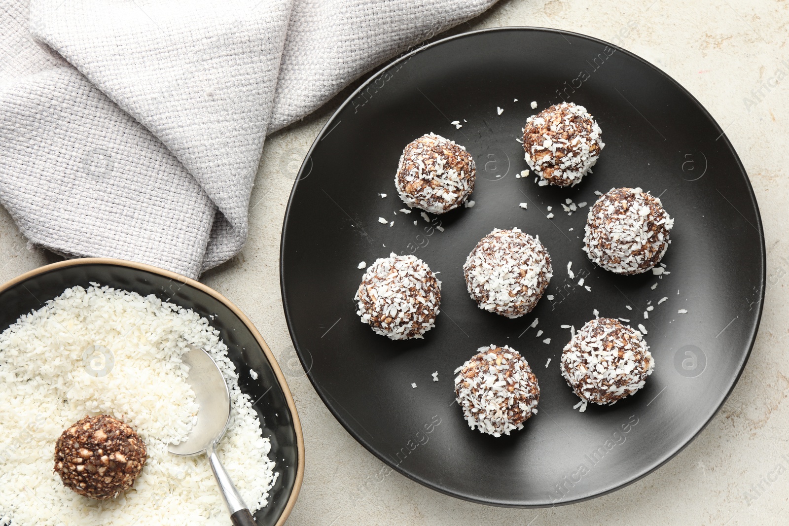 Tasty chocolate candies with coconut flakes on light table, flat lay Photo of Tasty chocolate candies with coconut flakes on light table, flat lay