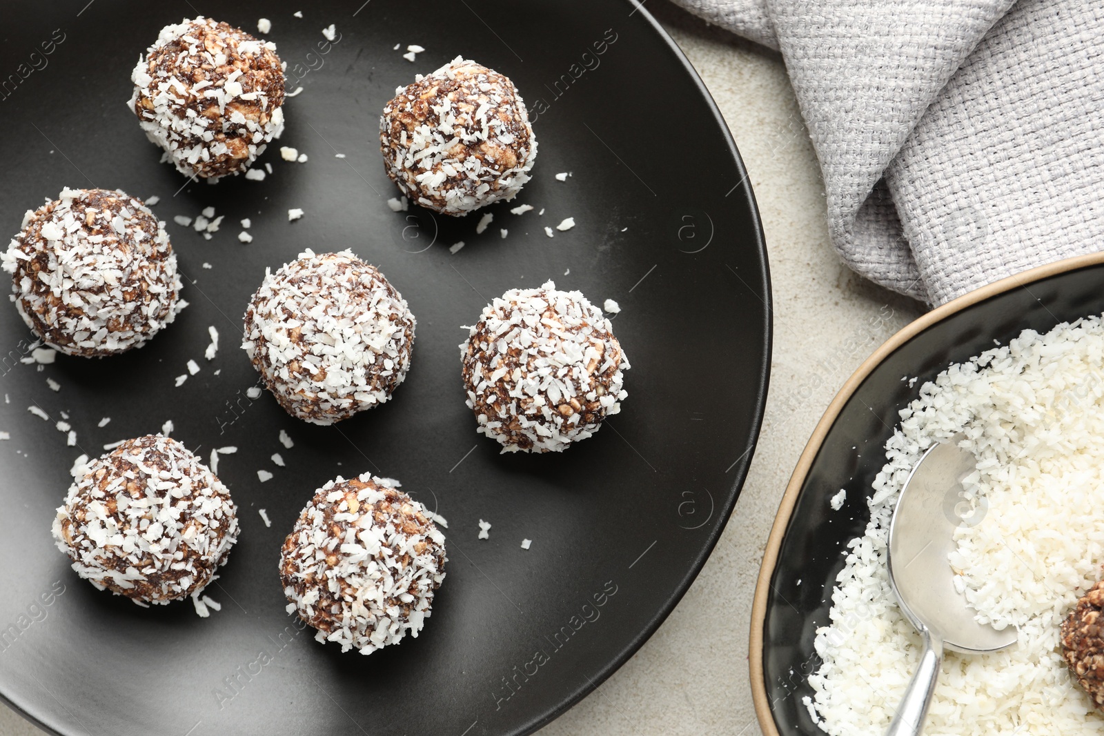 Tasty chocolate candies with coconut flakes on light table, flat lay Photo of Tasty chocolate candies with coconut flakes on light table, flat lay