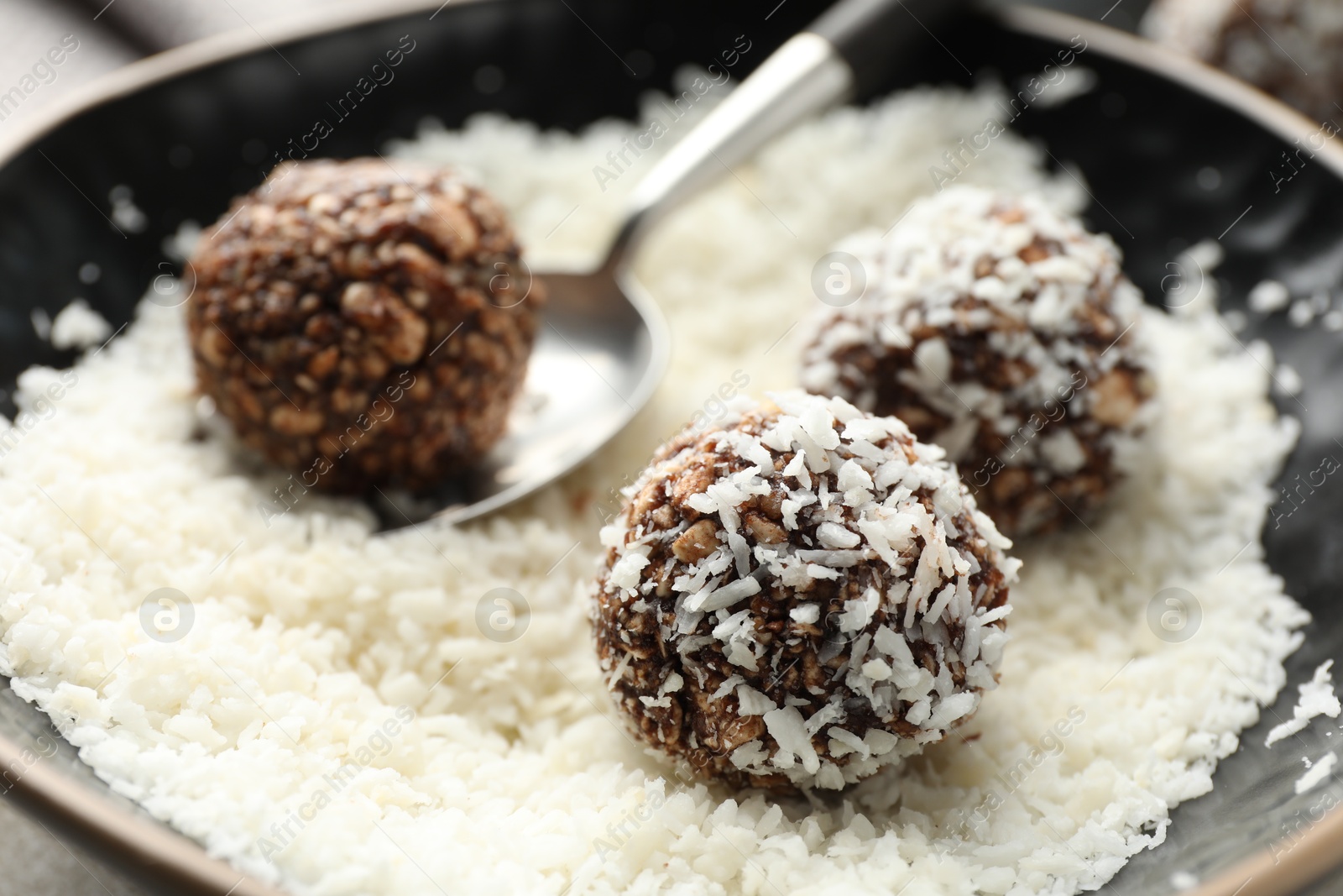 Making tasty chocolate candies with nuts and coconut flakes at light table, closeup Photo of Making tasty chocolate candies with nuts and coconut flakes at light table, closeup