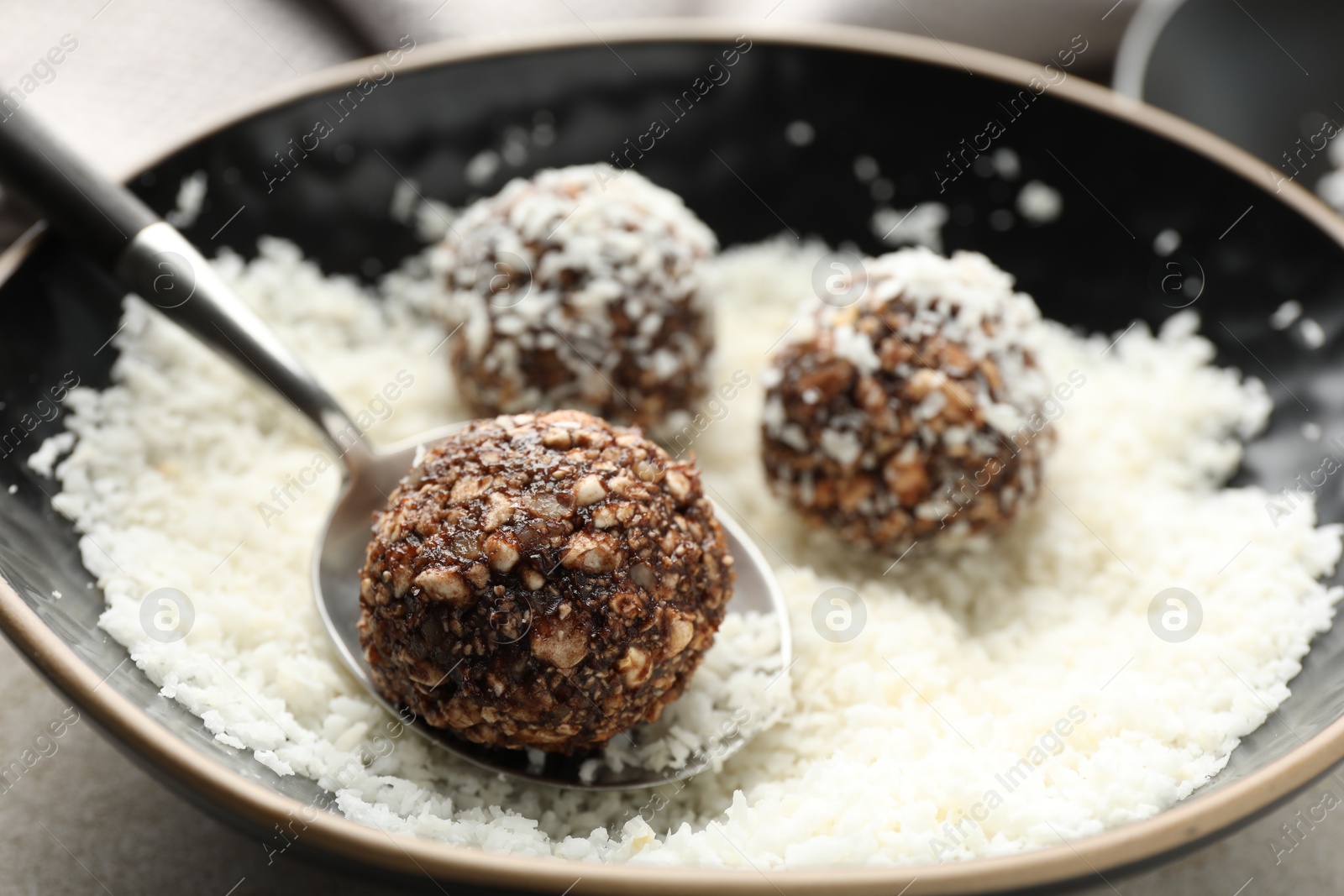 Making tasty chocolate candies with nuts and coconut flakes at light table, closeup Photo of Making tasty chocolate candies with nuts and coconut flakes at light table, closeup