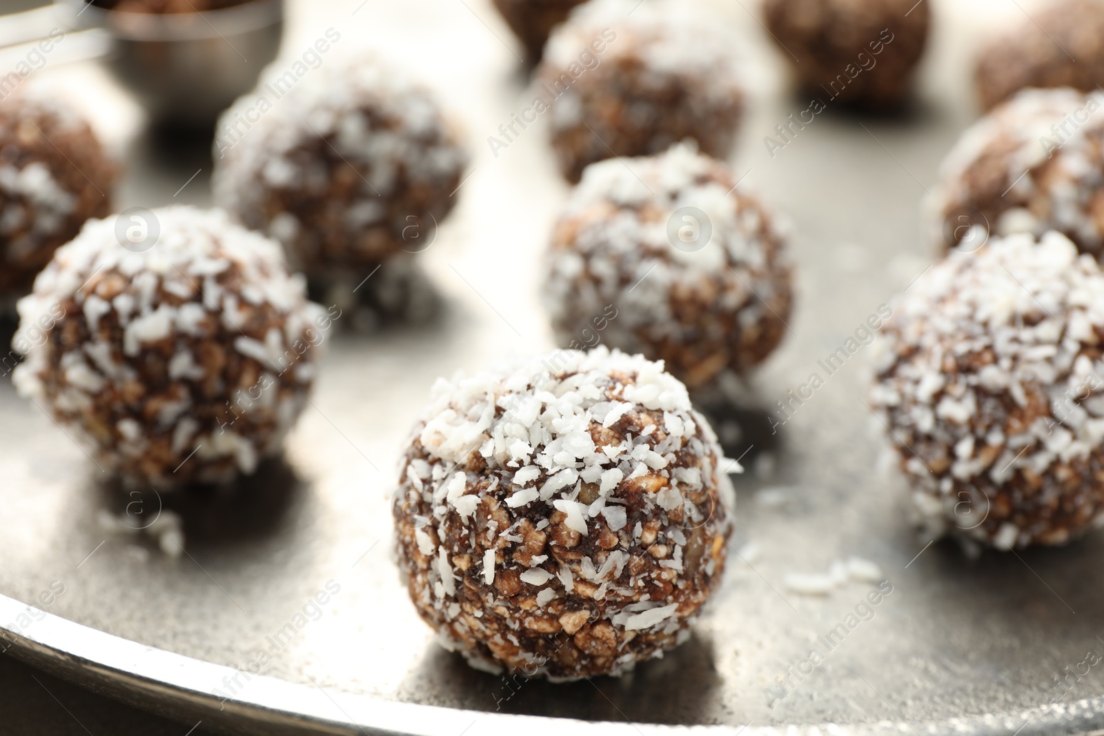 Tasty chocolate candies with nuts and coconut flakes on table, closeup Photo of Tasty chocolate candies with nuts and coconut flakes on table, closeup