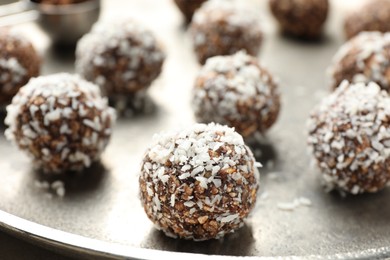 Photo of Tasty chocolate candies with nuts and coconut flakes on table, closeup