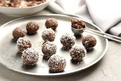 Photo of Tasty chocolate candies with nuts and coconut flakes on light table, closeup
