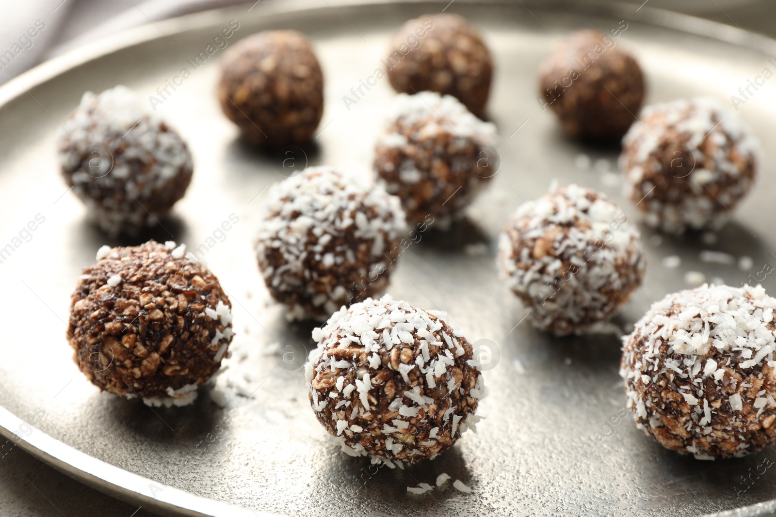 Tasty chocolate candies with nuts and coconut flakes on table, closeup Photo of Tasty chocolate candies with nuts and coconut flakes on table, closeup