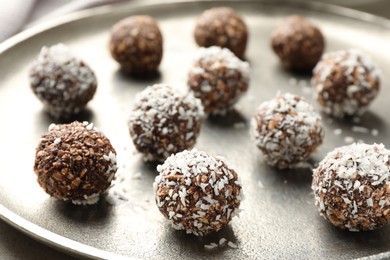 Photo of Tasty chocolate candies with nuts and coconut flakes on table, closeup