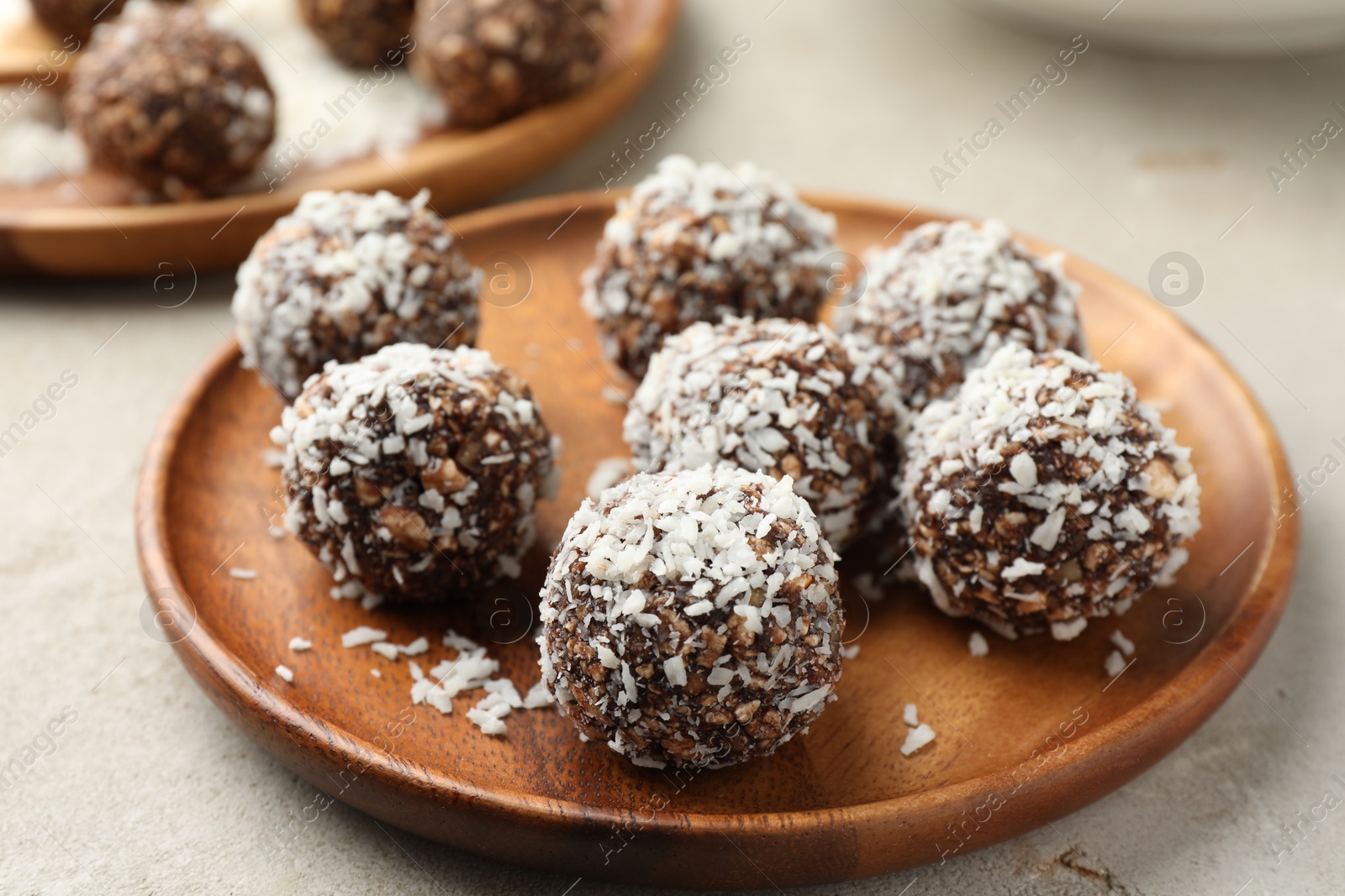 Tasty chocolate candies with nuts and coconut flakes on light table, closeup Photo of Tasty chocolate candies with nuts and coconut flakes on light table, closeup