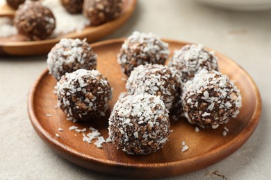 Photo of Tasty chocolate candies with nuts and coconut flakes on light table, closeup