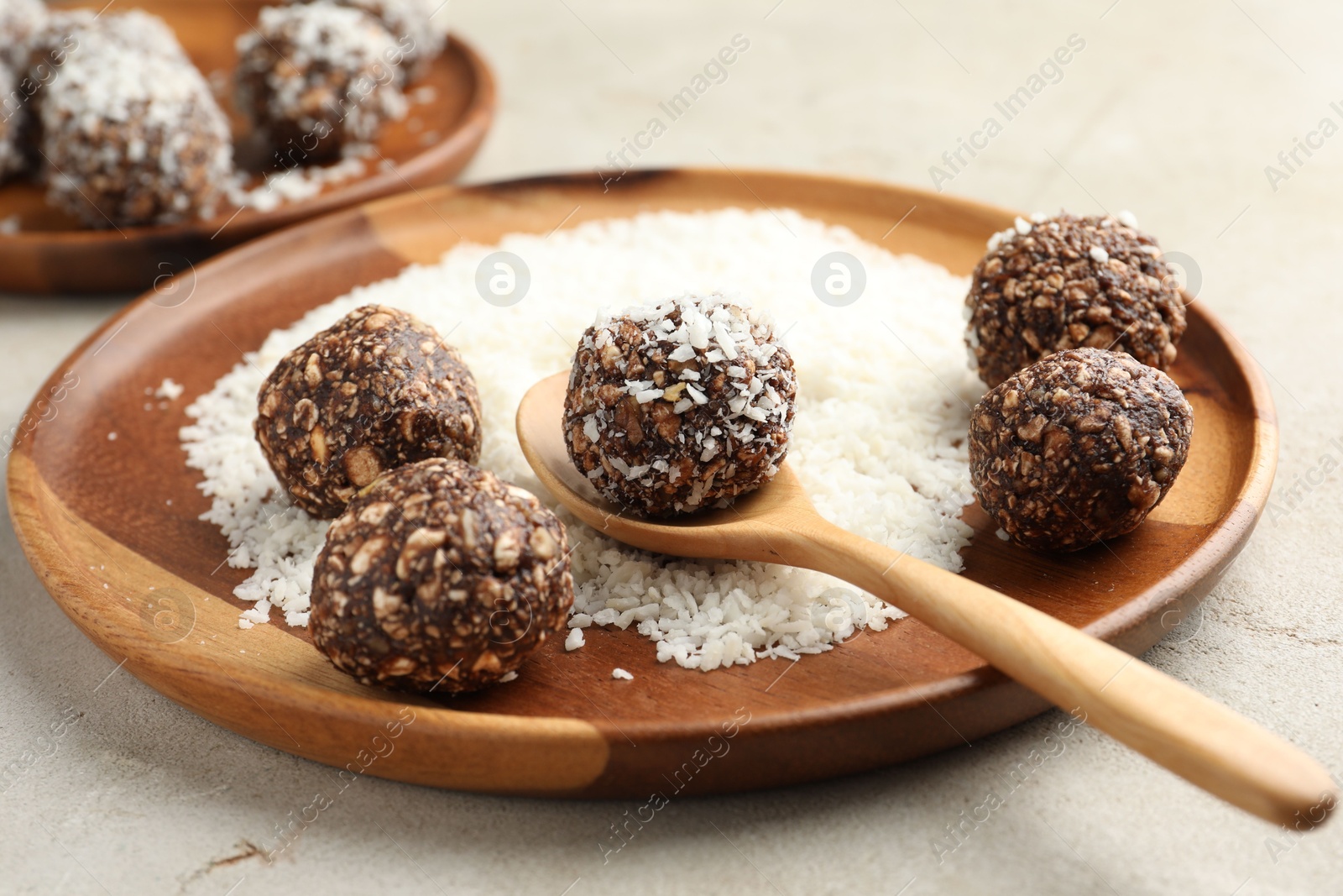 Making tasty chocolate candies with nuts and coconut flakes at light table, closeup Photo of Making tasty chocolate candies with nuts and coconut flakes at light table, closeup