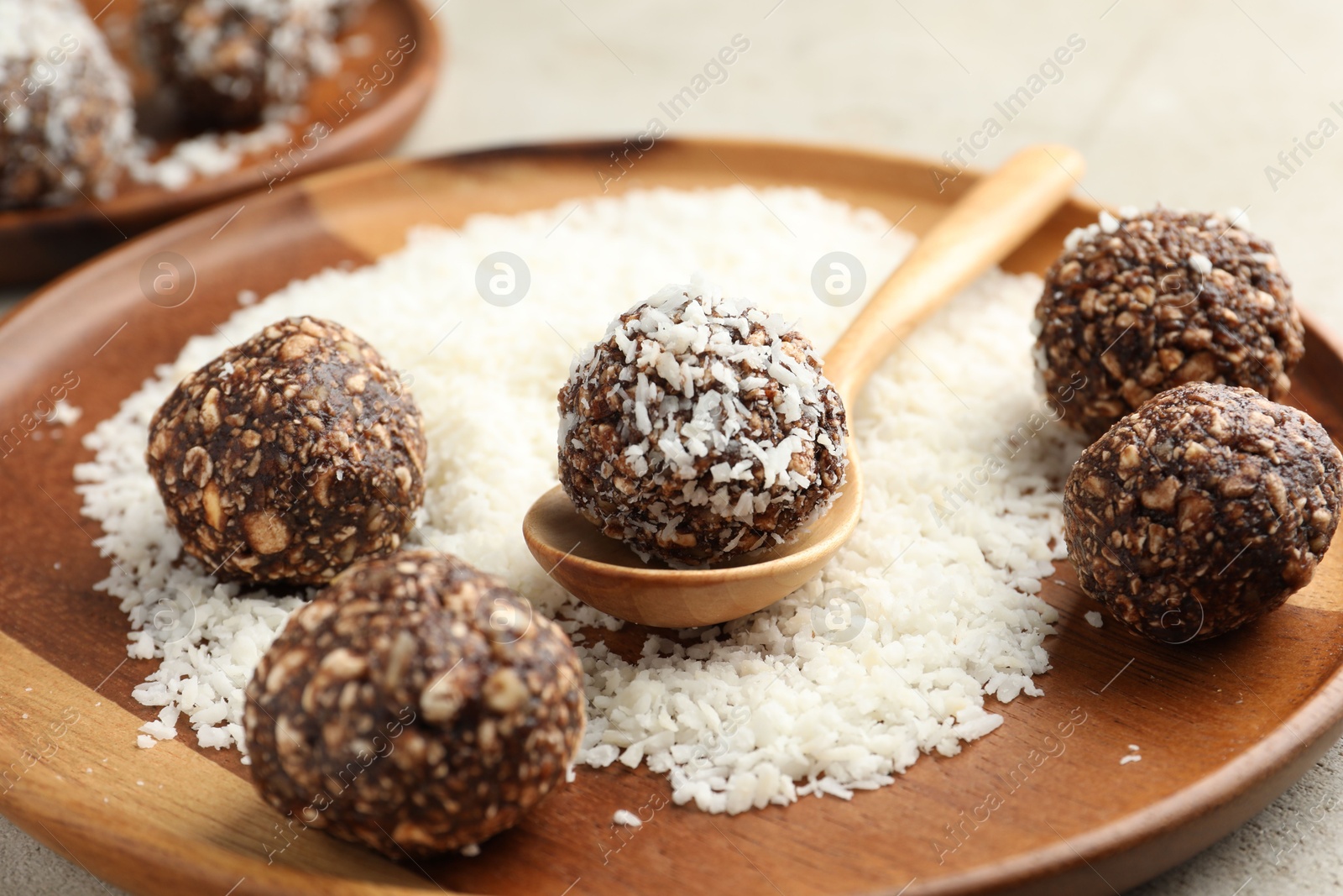 Making tasty chocolate candies with nuts and coconut flakes at light table, closeup Photo of Making tasty chocolate candies with nuts and coconut flakes at light table, closeup