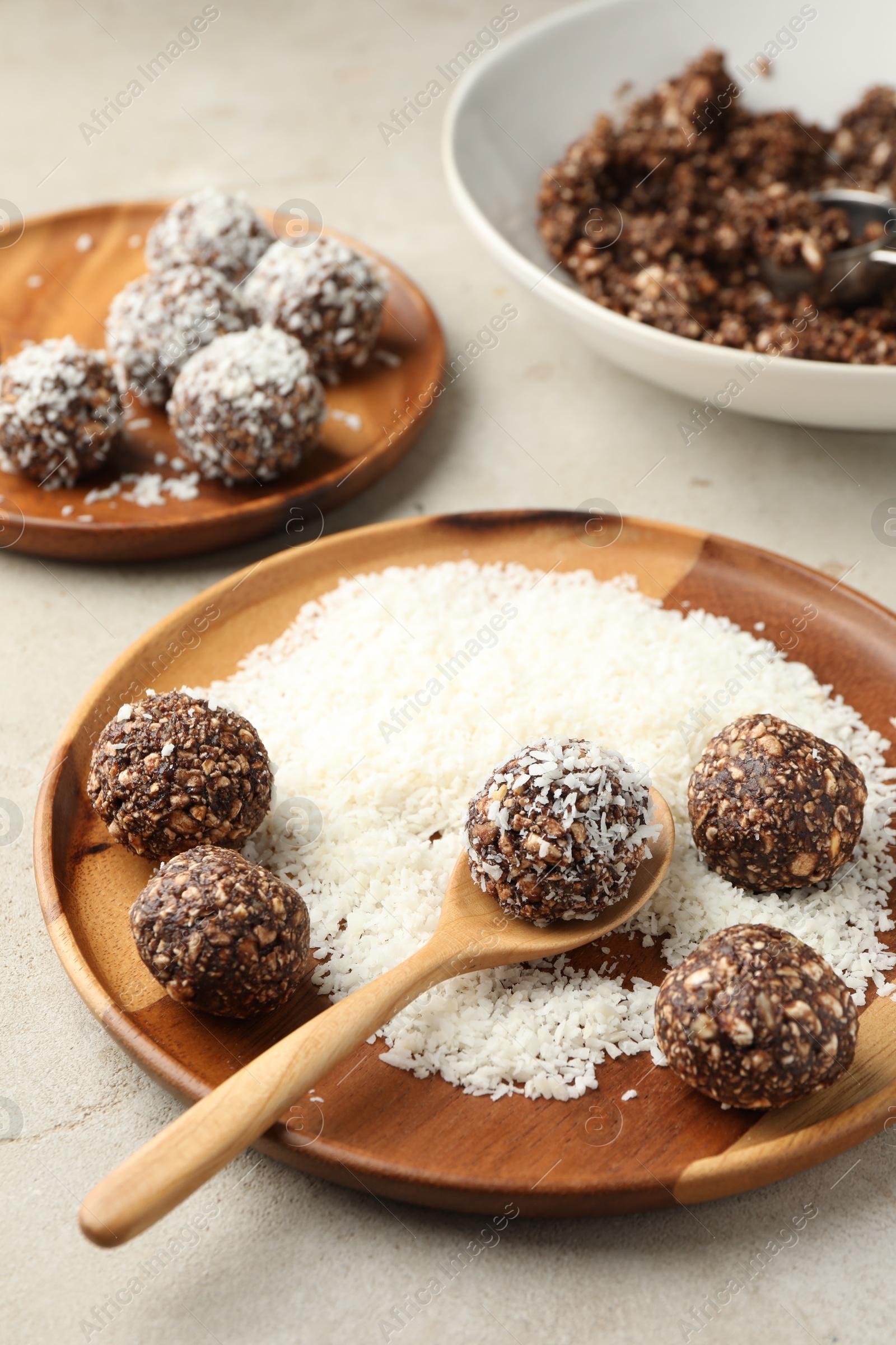 Making tasty chocolate candies with nuts and coconut flakes at light table, closeup Photo of Making tasty chocolate candies with nuts and coconut flakes at light table, closeup