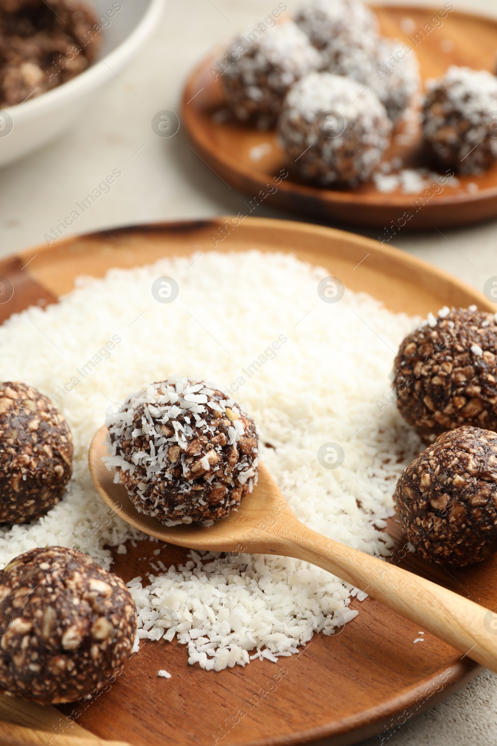Making tasty chocolate candies with nuts and coconut flakes at light table, closeup Photo of Making tasty chocolate candies with nuts and coconut flakes at light table, closeup