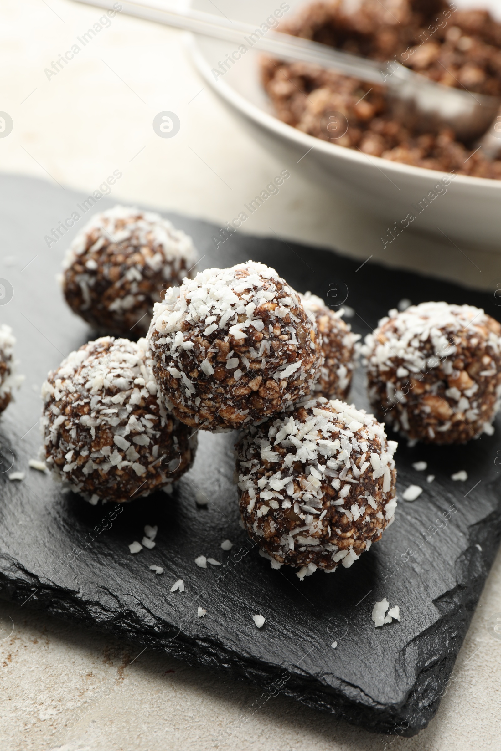 Tasty chocolate candies with nuts and coconut flakes on light table, closeup Photo of Tasty chocolate candies with nuts and coconut flakes on light table, closeup