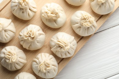 Photo of Uncooked khinkalis (dumplings) on white wooden table, top view