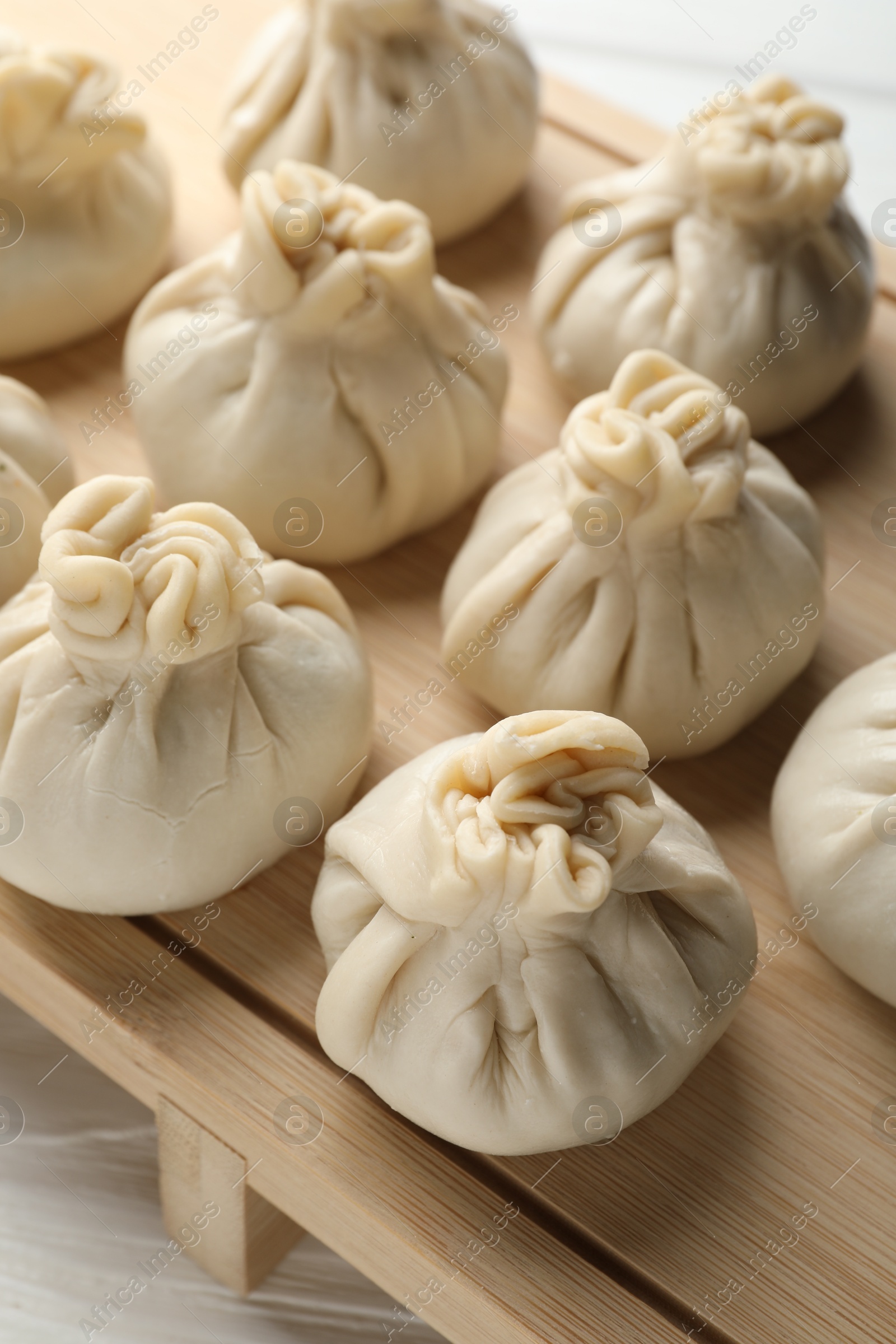 Uncooked khinkalis (dumplings) on white wooden table, closeup Photo of Uncooked khinkalis (dumplings) on white wooden table, closeup