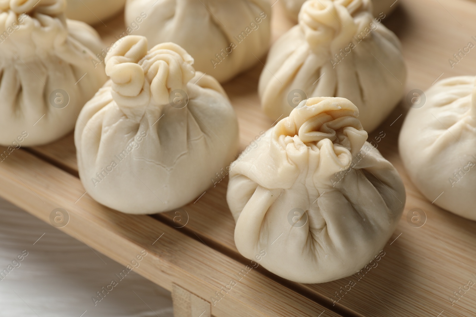 Uncooked khinkalis (dumplings) on white wooden table, closeup Photo of Uncooked khinkalis (dumplings) on white wooden table, closeup