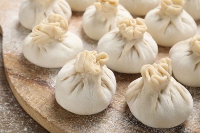 Photo of Many uncooked khinkalis (dumplings) on table, closeup