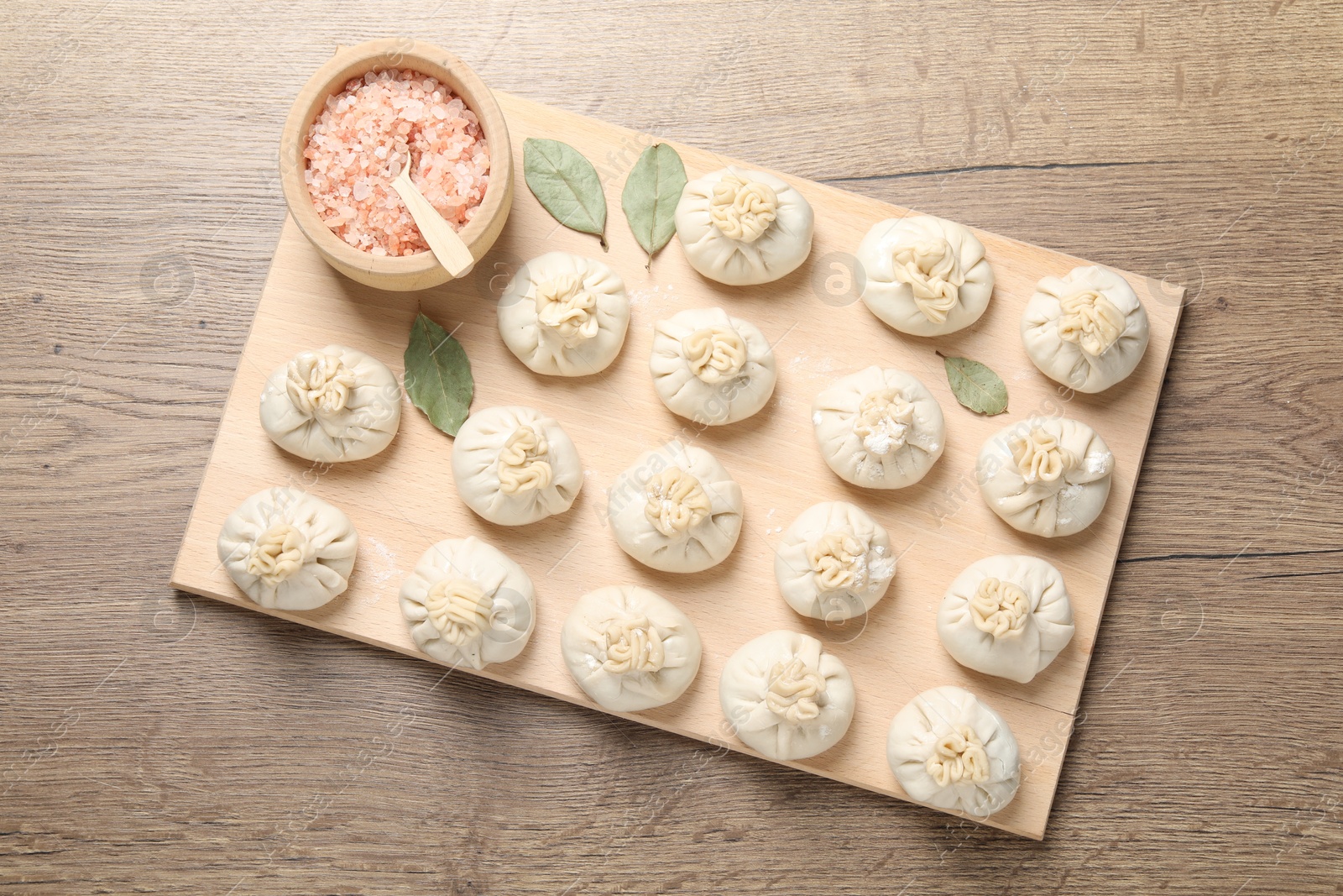 Uncooked khinkalis (dumplings) and spices on wooden table, top view Photo of Uncooked khinkalis (dumplings) and spices on wooden table, top view