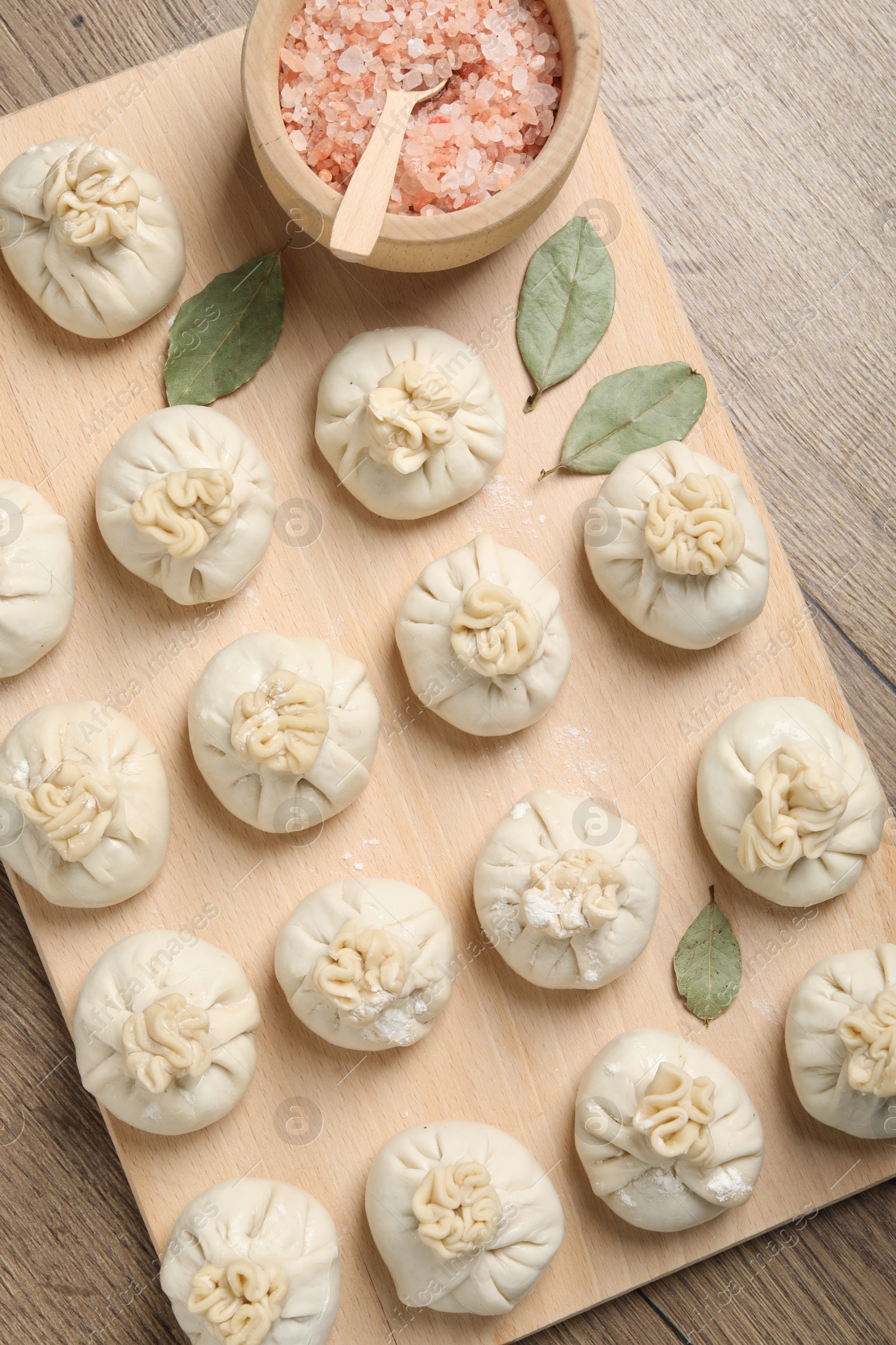 Uncooked khinkalis (dumplings) and spices on wooden table, top view Photo of Uncooked khinkalis (dumplings) and spices on wooden table, top view