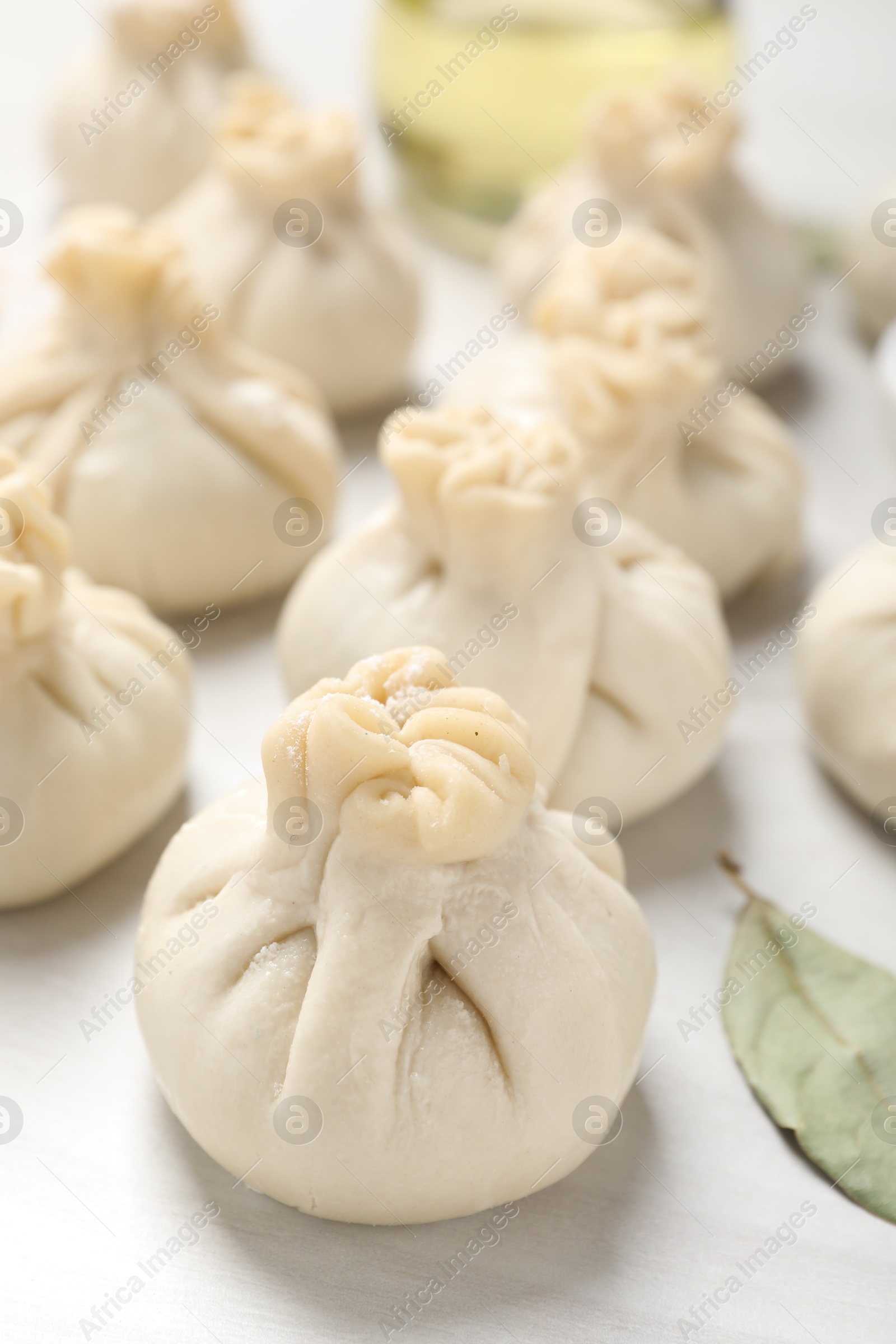 Uncooked khinkalis (dumplings) on white wooden table, closeup Photo of Uncooked khinkalis (dumplings) on white wooden table, closeup