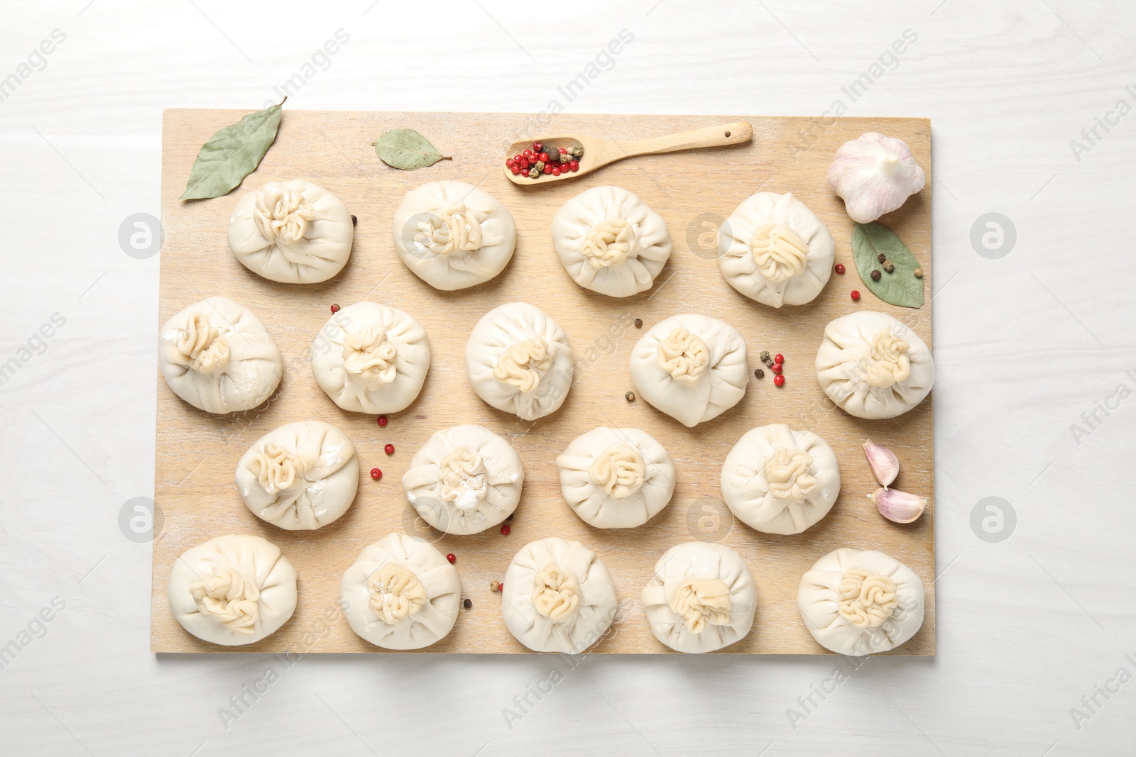 Uncooked khinkalis (dumplings) and spices on white wooden table, top view Photo of Uncooked khinkalis (dumplings) and spices on white wooden table, top view