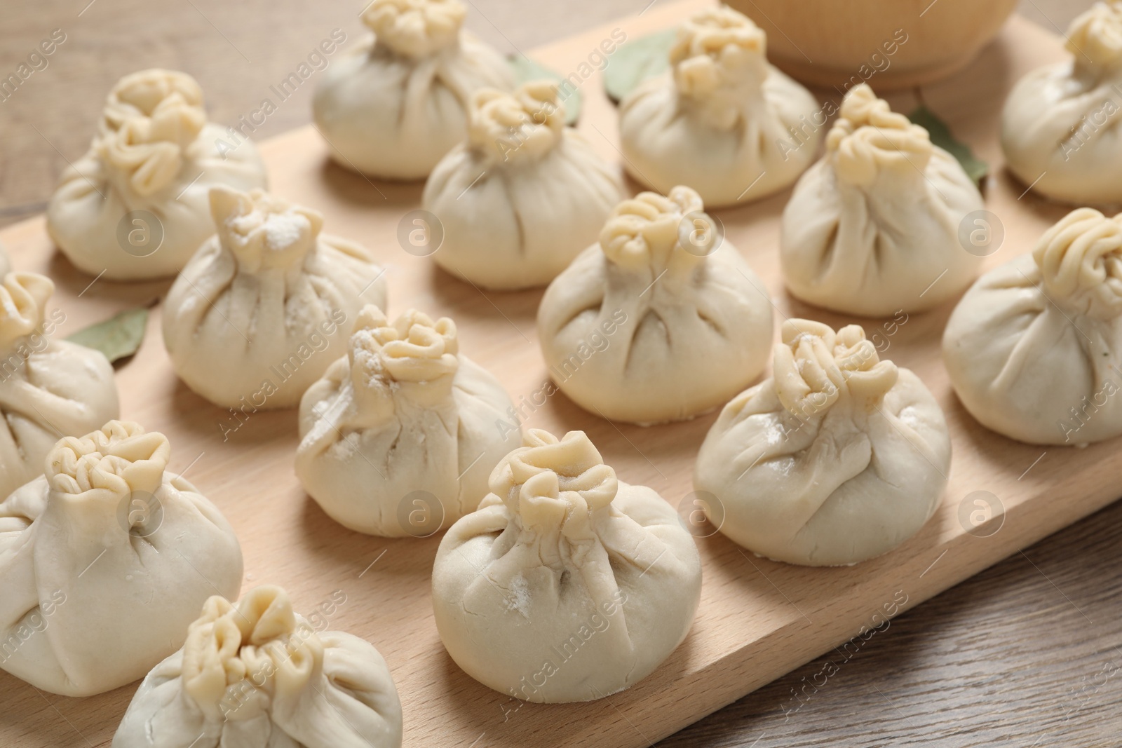 Uncooked khinkalis (dumplings) on wooden table, closeup Photo of Uncooked khinkalis (dumplings) on wooden table, closeup