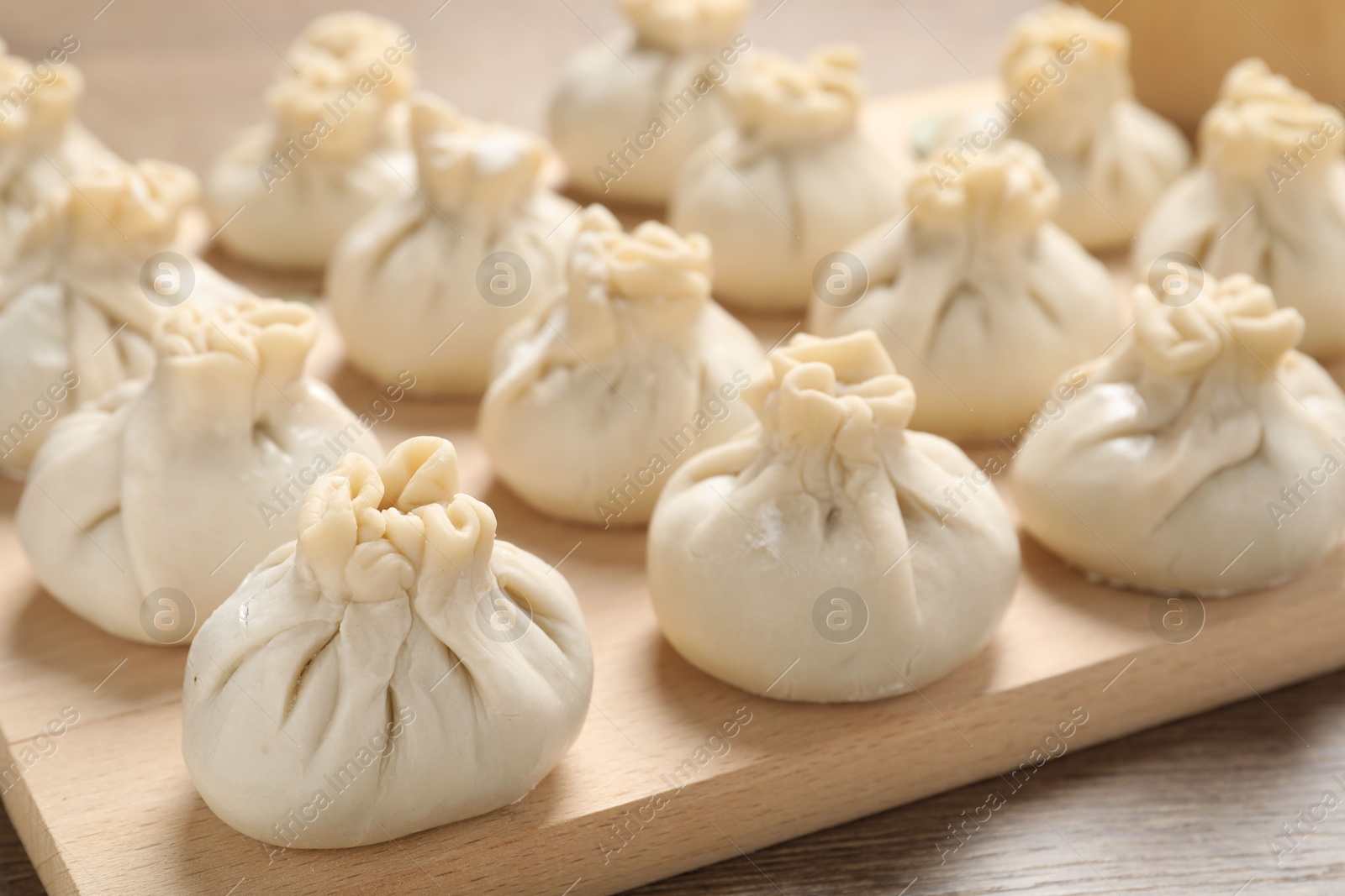 Uncooked khinkalis (dumplings) on wooden table, closeup Photo of Uncooked khinkalis (dumplings) on wooden table, closeup