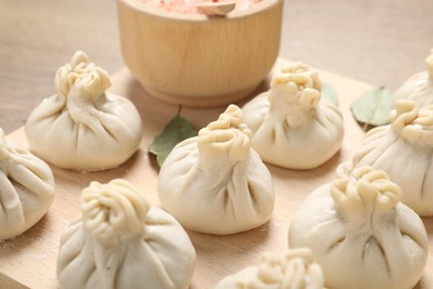 Photo of Uncooked khinkalis (dumplings) and spices on table, closeup
