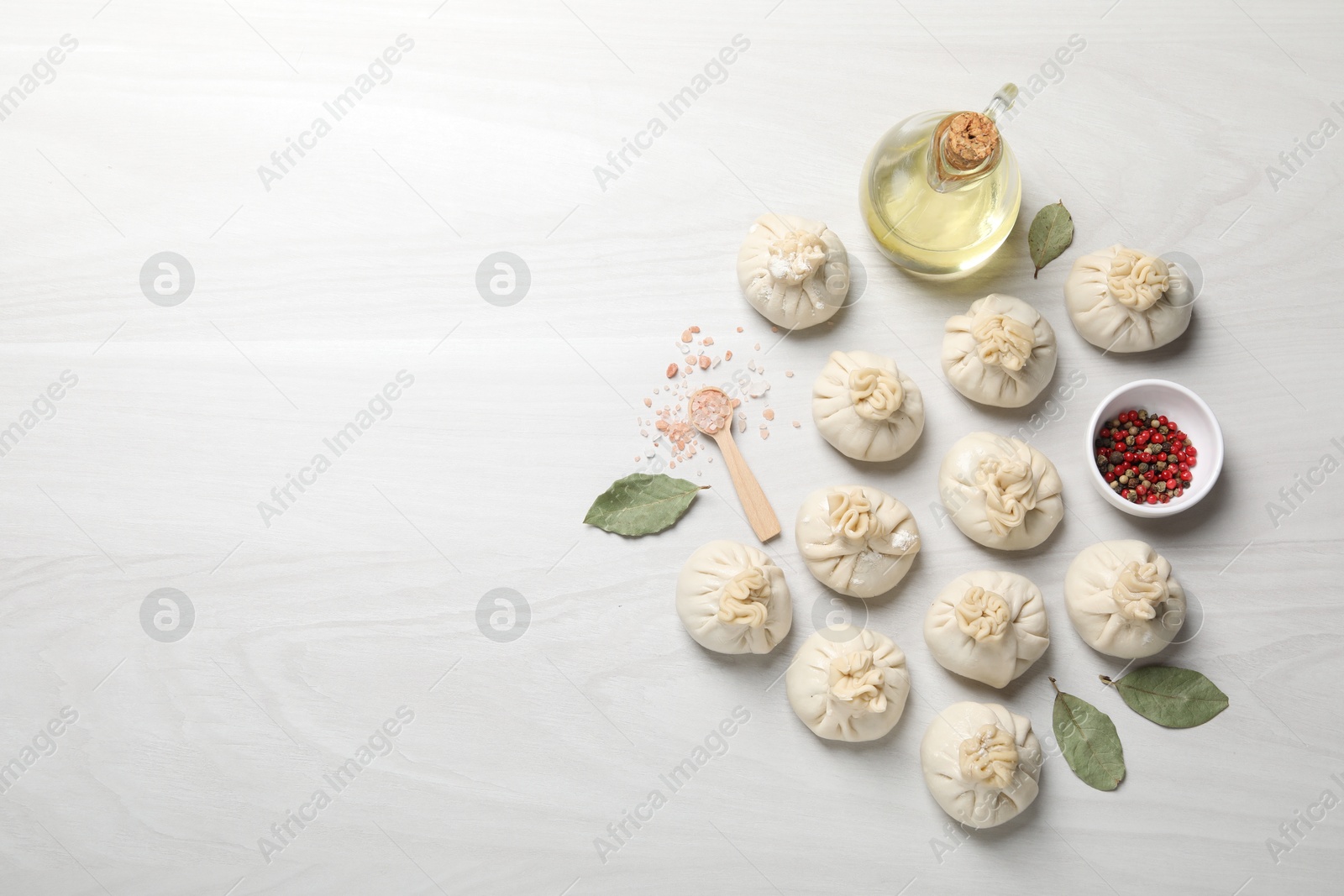 Uncooked khinkalis (dumplings) and spices on white wooden table, flat lay. Space for text Photo of Uncooked khinkalis (dumplings) and spices on white wooden table, flat lay. Space for text