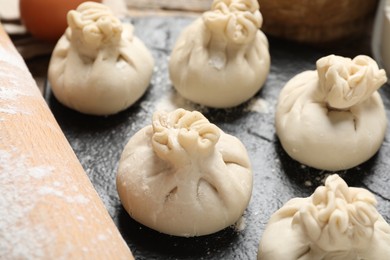 Photo of Many uncooked khinkalis (dumplings) on table, closeup