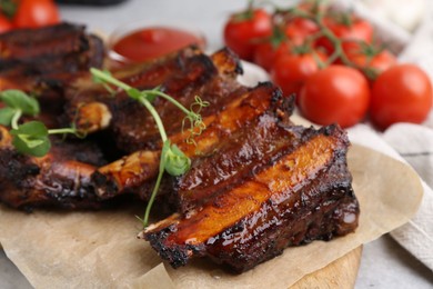 Photo of Roasted beef ribs with microgreens and tomatoes on table, closeup