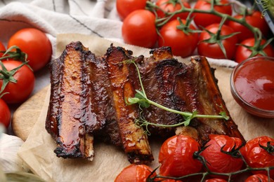 Photo of Roasted beef ribs with microgreens, tomatoes and sauce on table, closeup